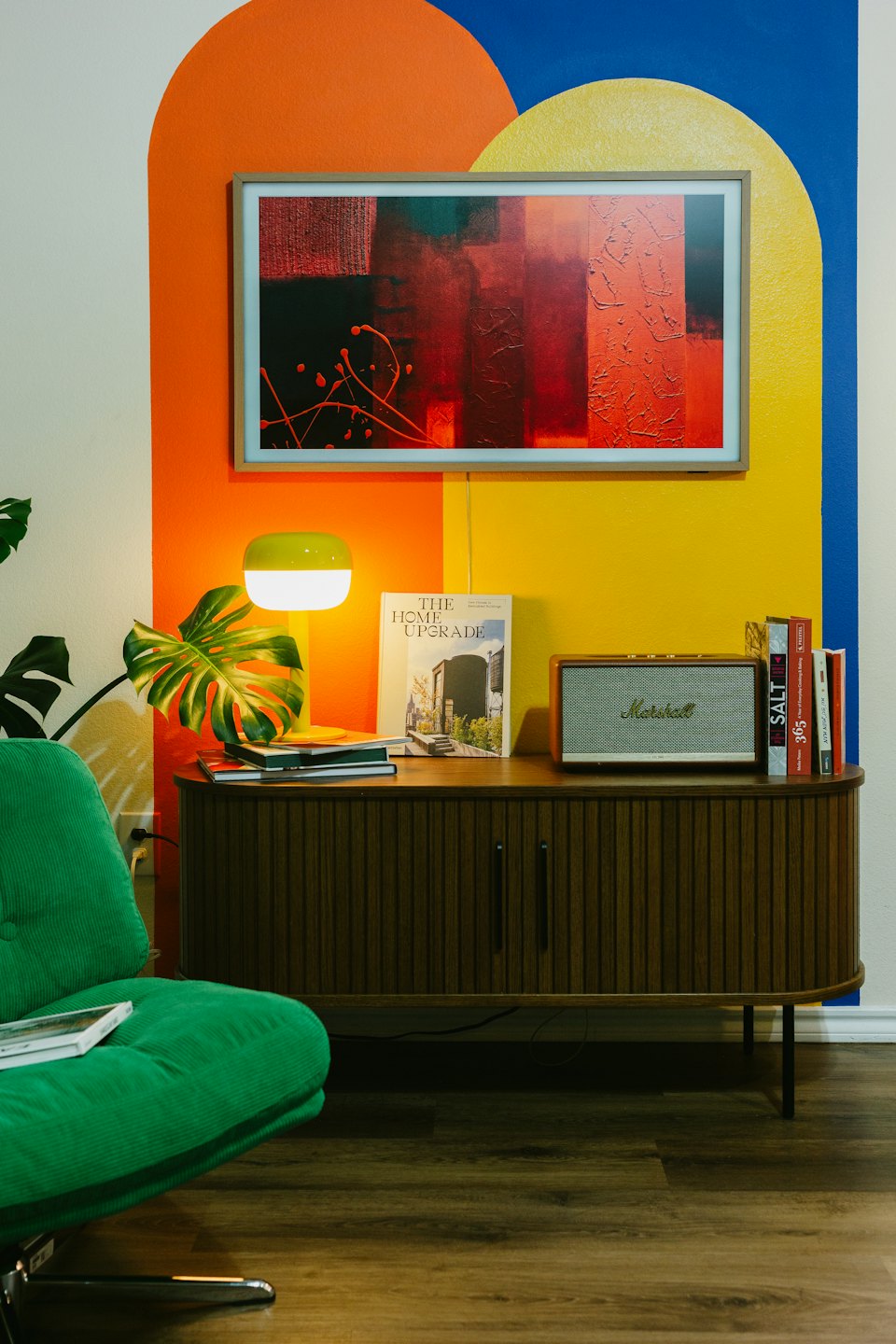 Modern living room with abstract art on a colorful wall.