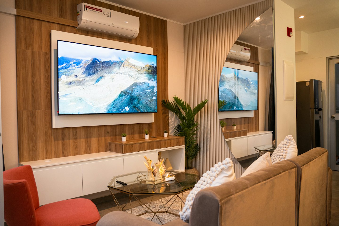 Modern living room with a large television and comfortable furniture.