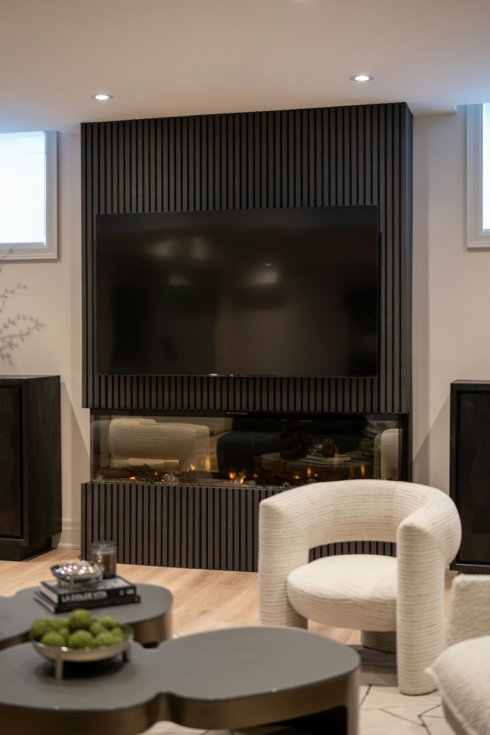Modern living room with entertainment unit and armchairs.